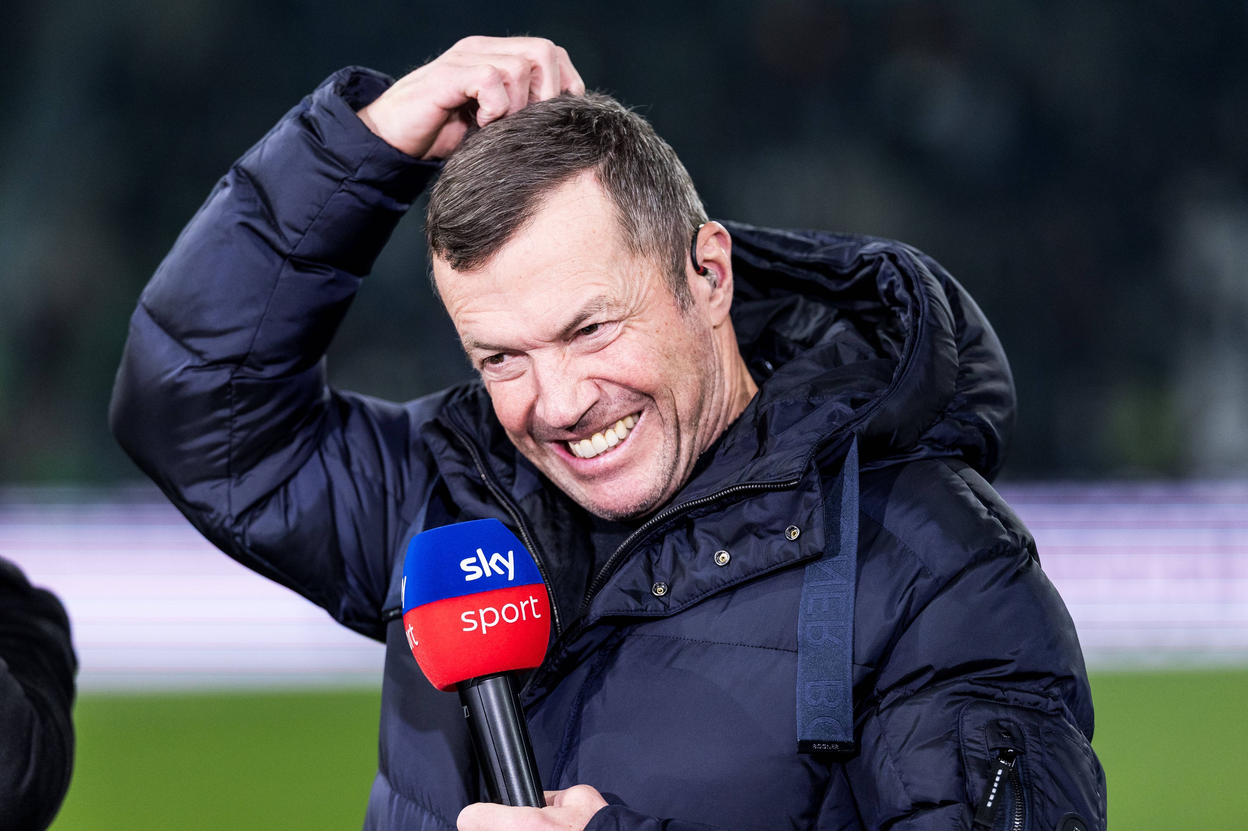 Lothar Matthäus kratzt sich mit Sky-Mikrofon in der Hand am Kopf.