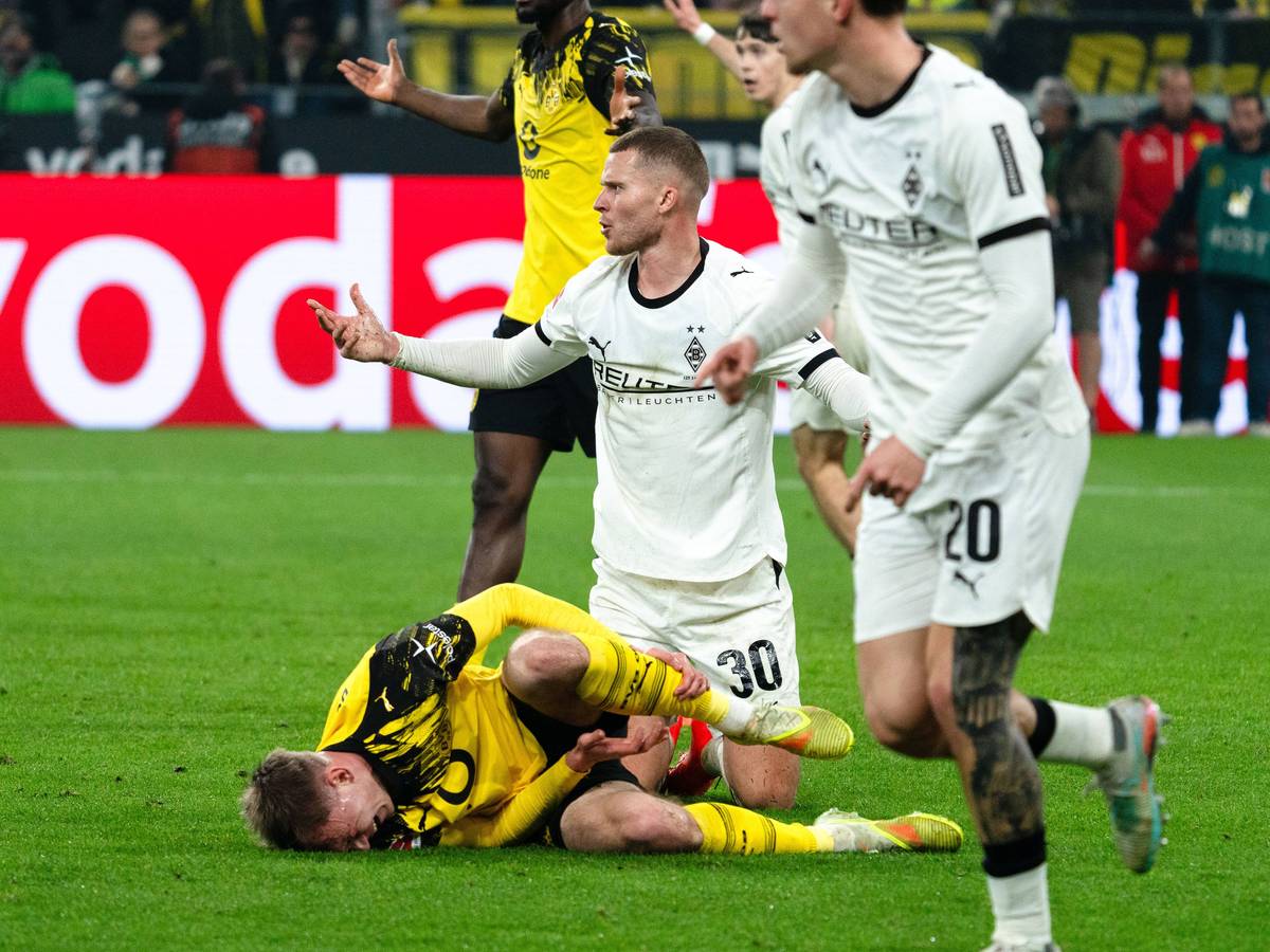 Nico Elvedi sitzt nach einem Zweikampf mit Dortmunds Maxi Beier am Boden.