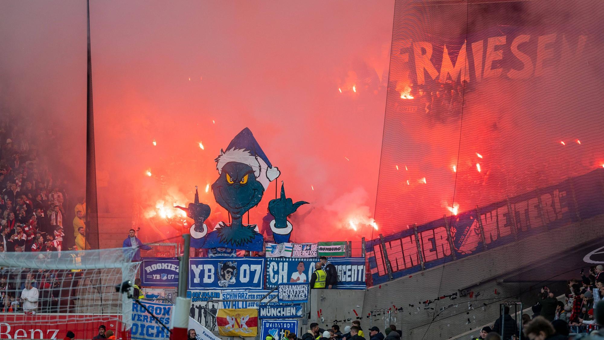 Hoffenheim-Fans zeigen einen Grinch, der beide Mittelfinger in die Luft streckt.