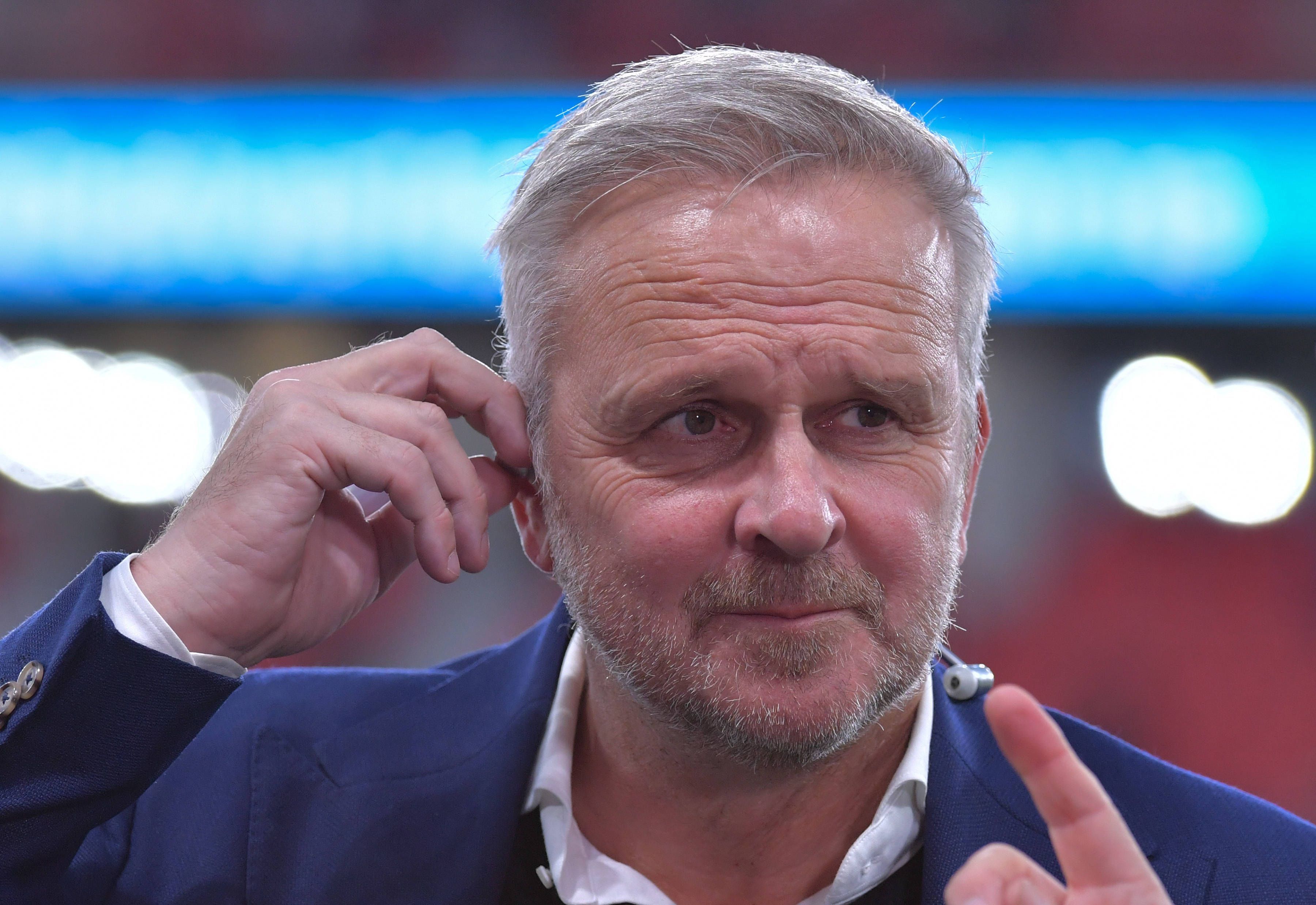 Dietmar Hamann richtet sich seinen In-Ear-Kopfhörer.