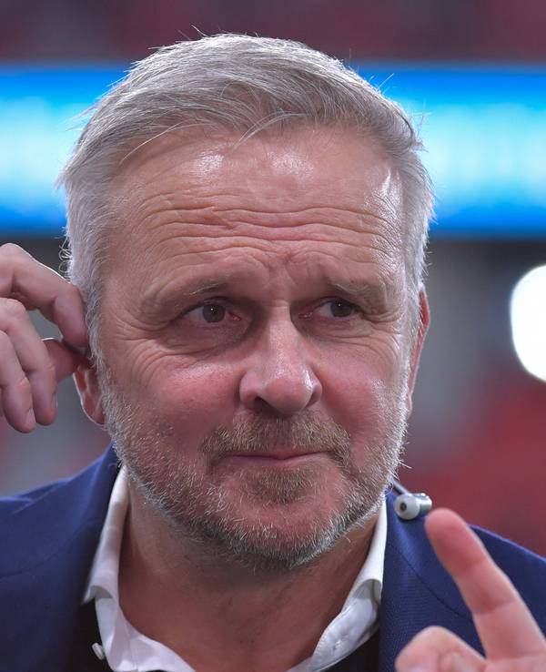 Dietmar Hamann richtet sich seinen In-Ear-Kopfhörer.