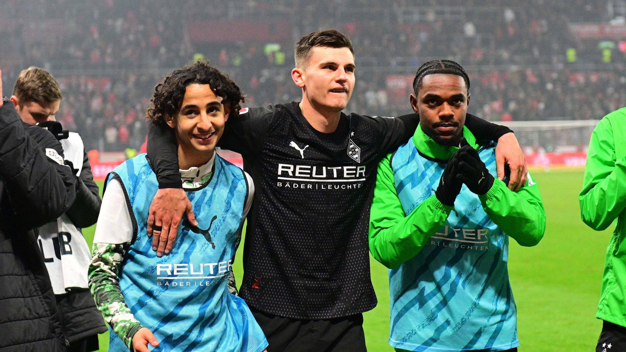 Nach dem Spiel von Borussia Mönchengladbach hat Yannik Engelhardt seine Arme um Charles Herrmann (r.) und Wael Mohya gelegt.