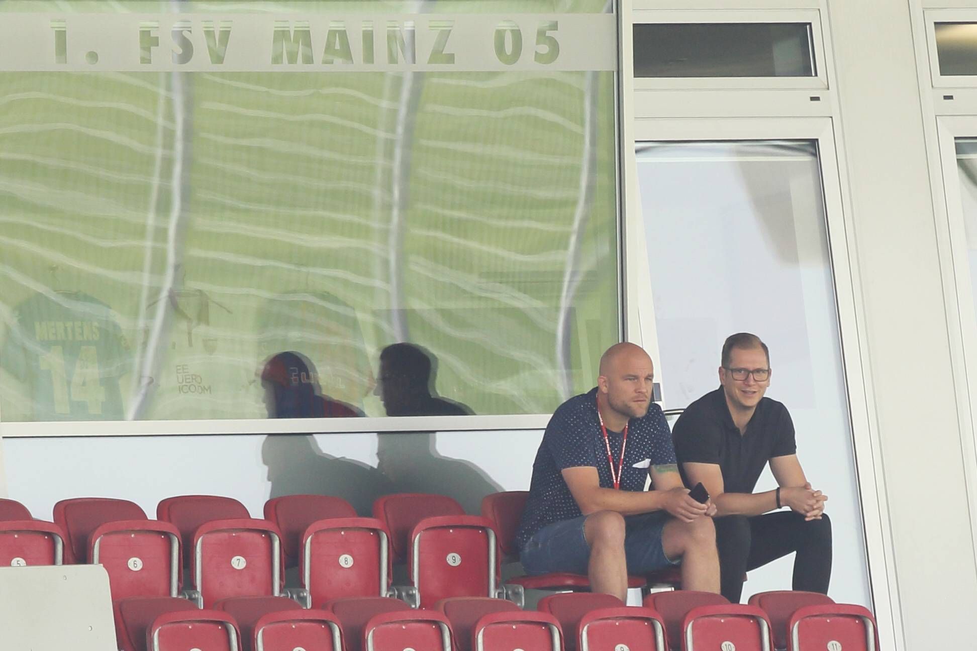 Rouven Schröder und Andre Hechelmann sitzen nebeneinander auf der Tribüne.