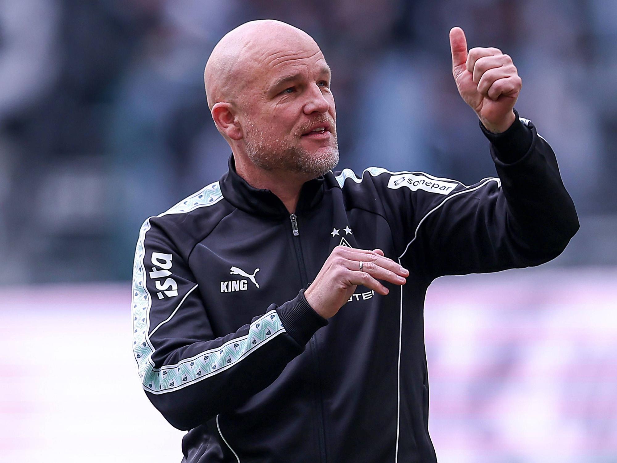Rouven Schröder zeigt im Stadion einen Daumen nach oben.