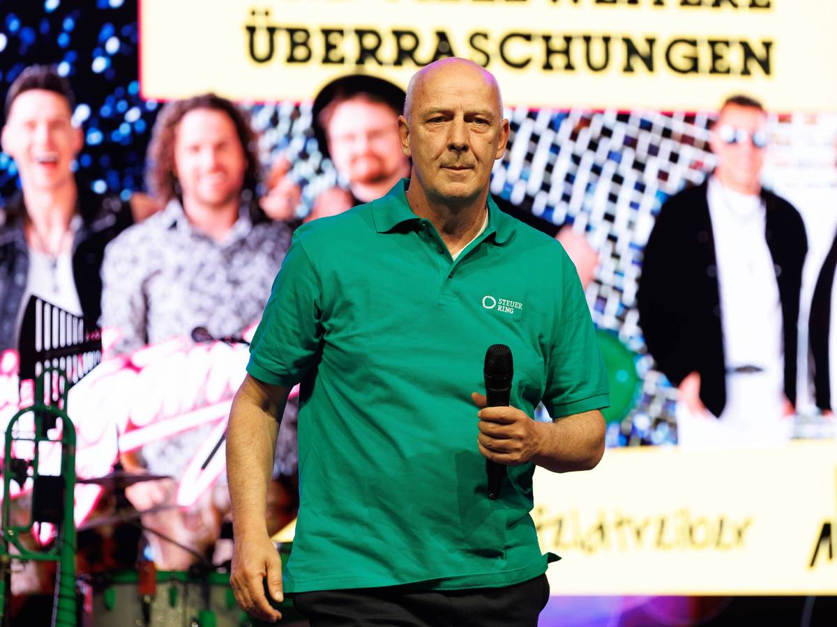 Mario Basler auf der Bühne mit Mikrofon in der Hand.
