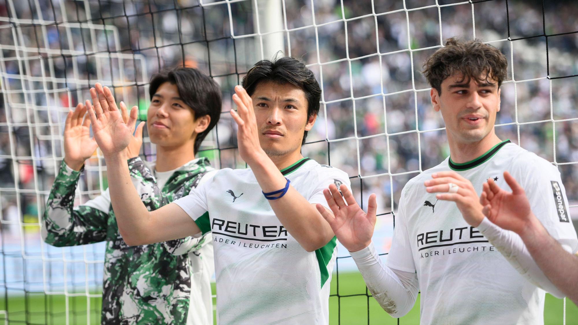 Kota Takai, Shuto Machino und Gio Reyna klatschen vor der Fankurve.
