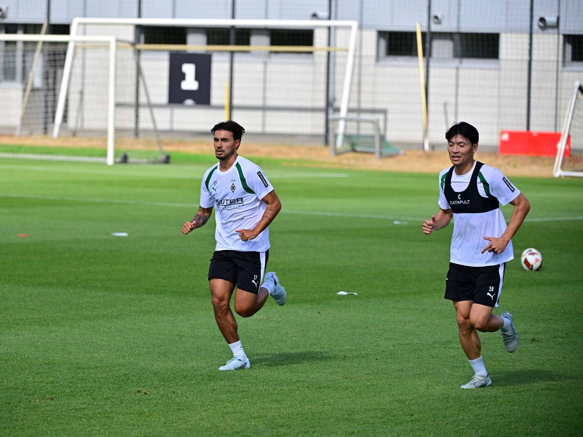 Jens Castrop (l.) und Shuto Machino laufen auf dem Trainingsplatz.
