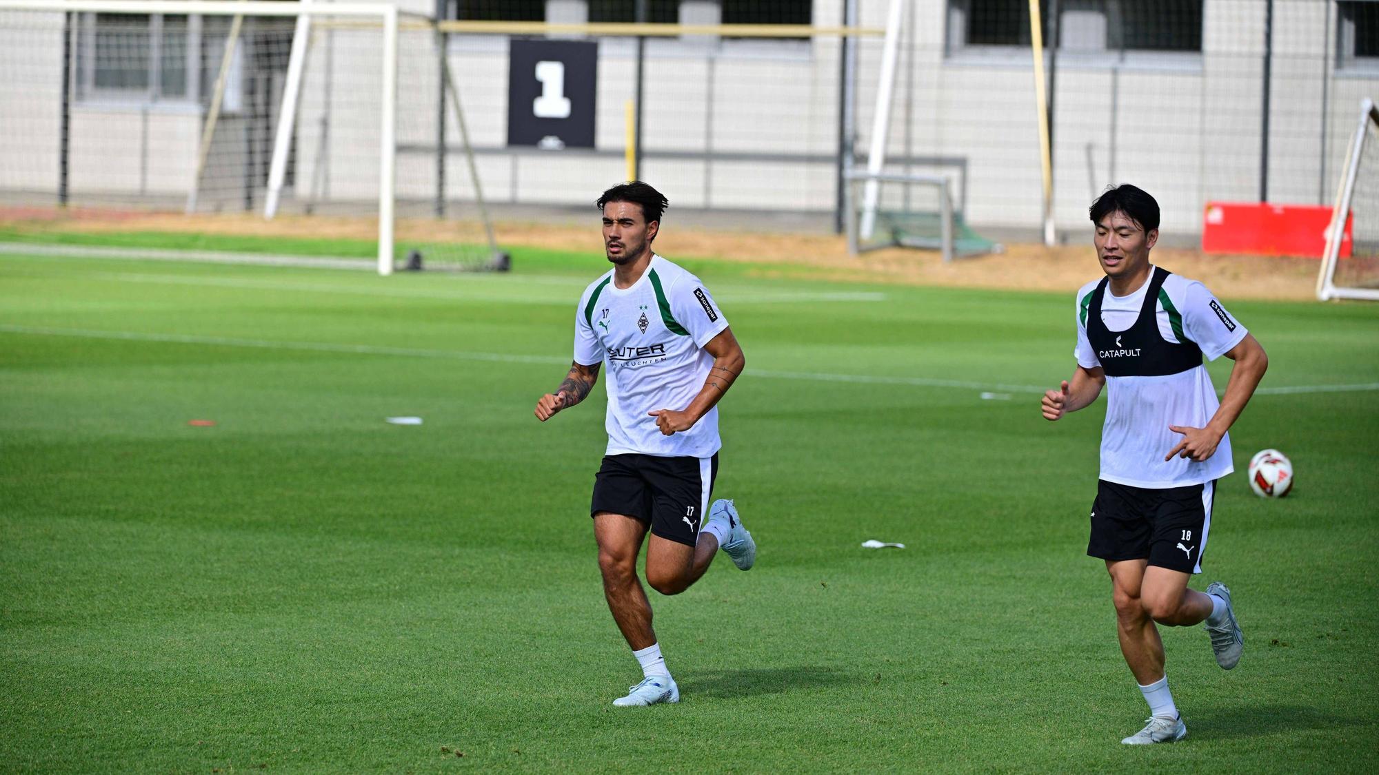Jens Castrop (l.) und Shuto Machino laufen auf dem Trainingsplatz.