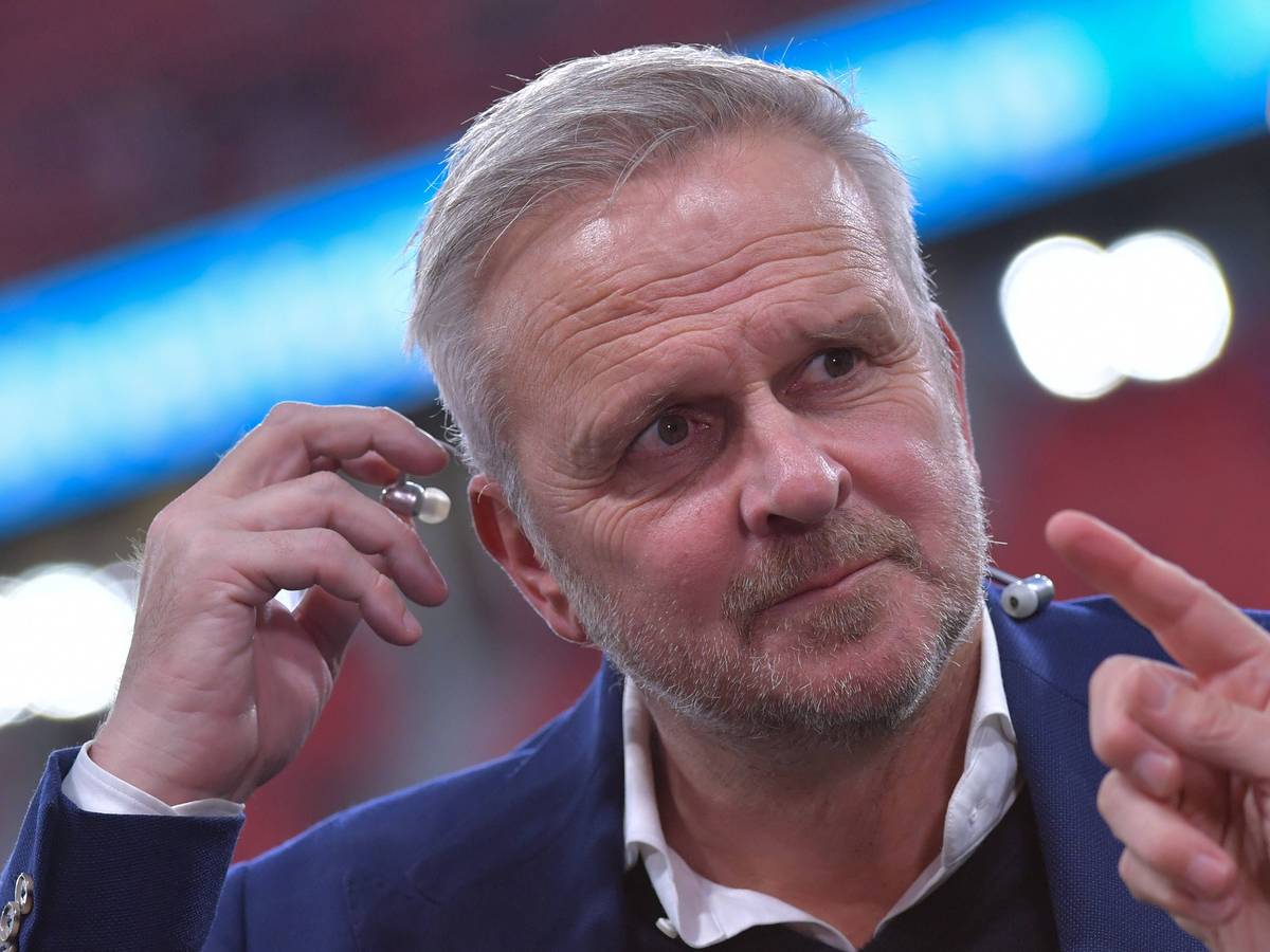 Dietmar Hamann steckt sich einen Kopfhörer ins Ohr.
