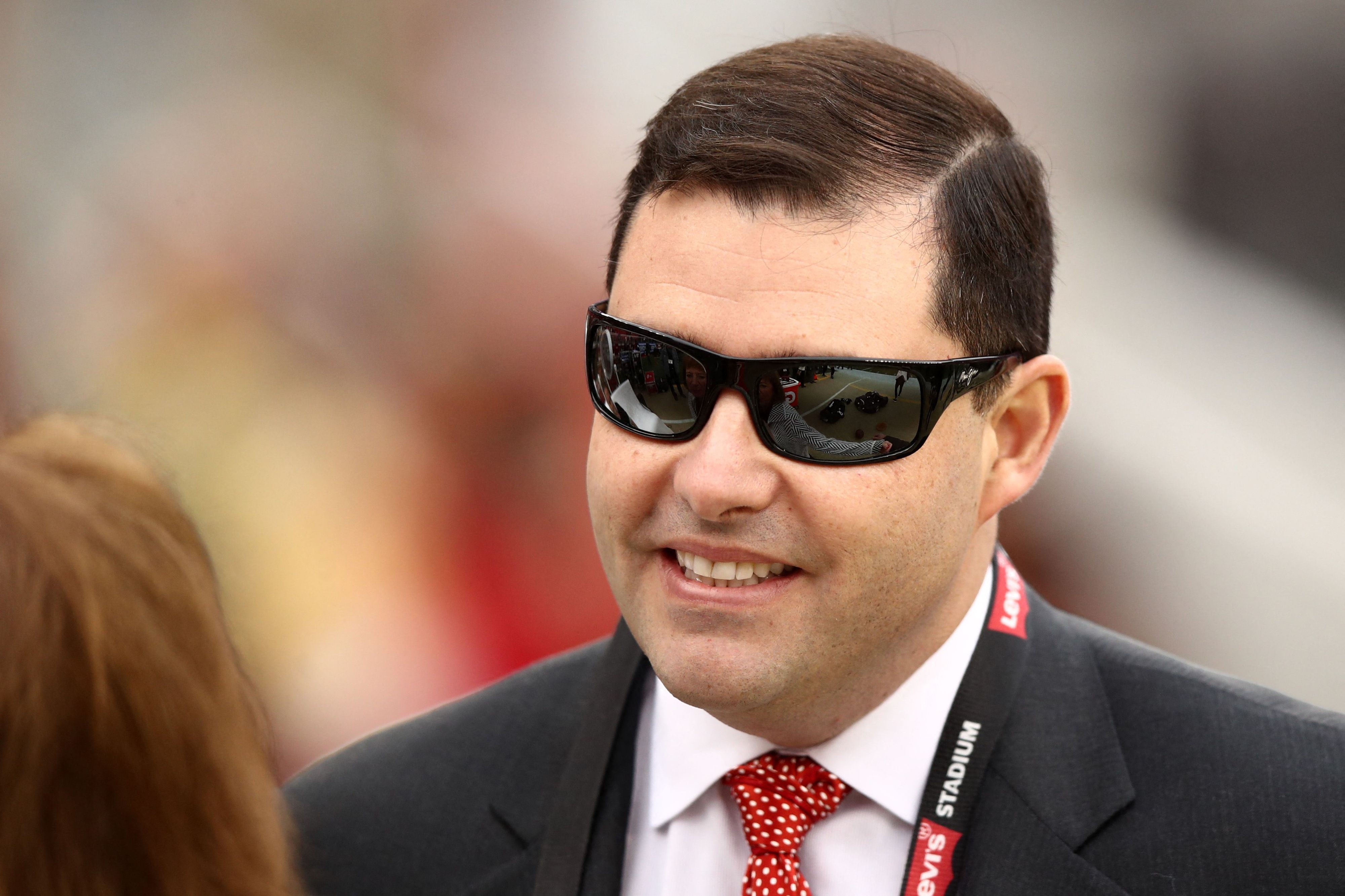 Jed York lächelt mit Sonnenbrille und Anzug