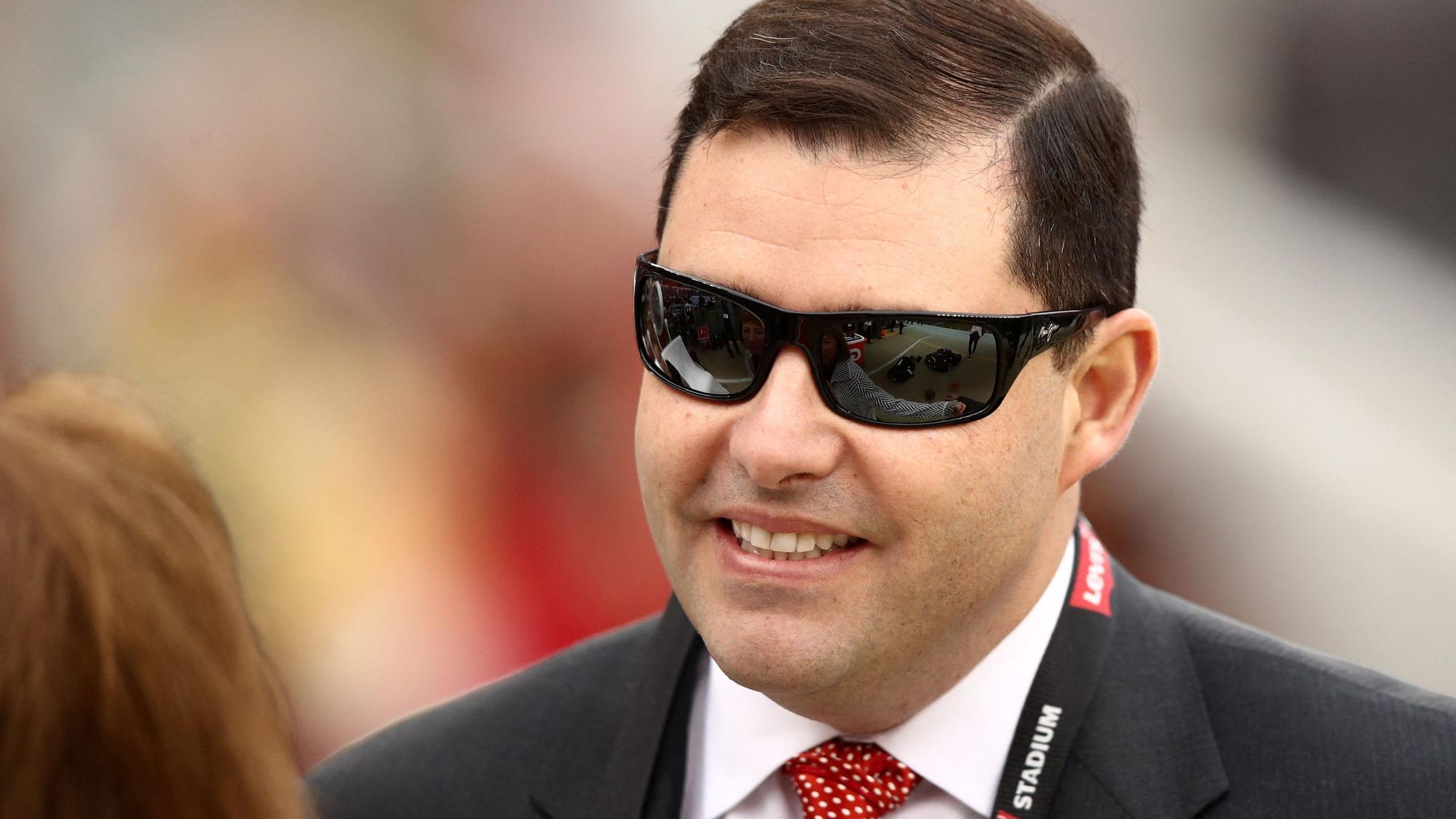 Jed York lächelt mit Sonnenbrille und Anzug