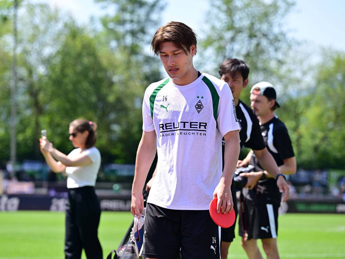 Daiki Hashioka hat während des Trainings ein Hütchen in der Hand.