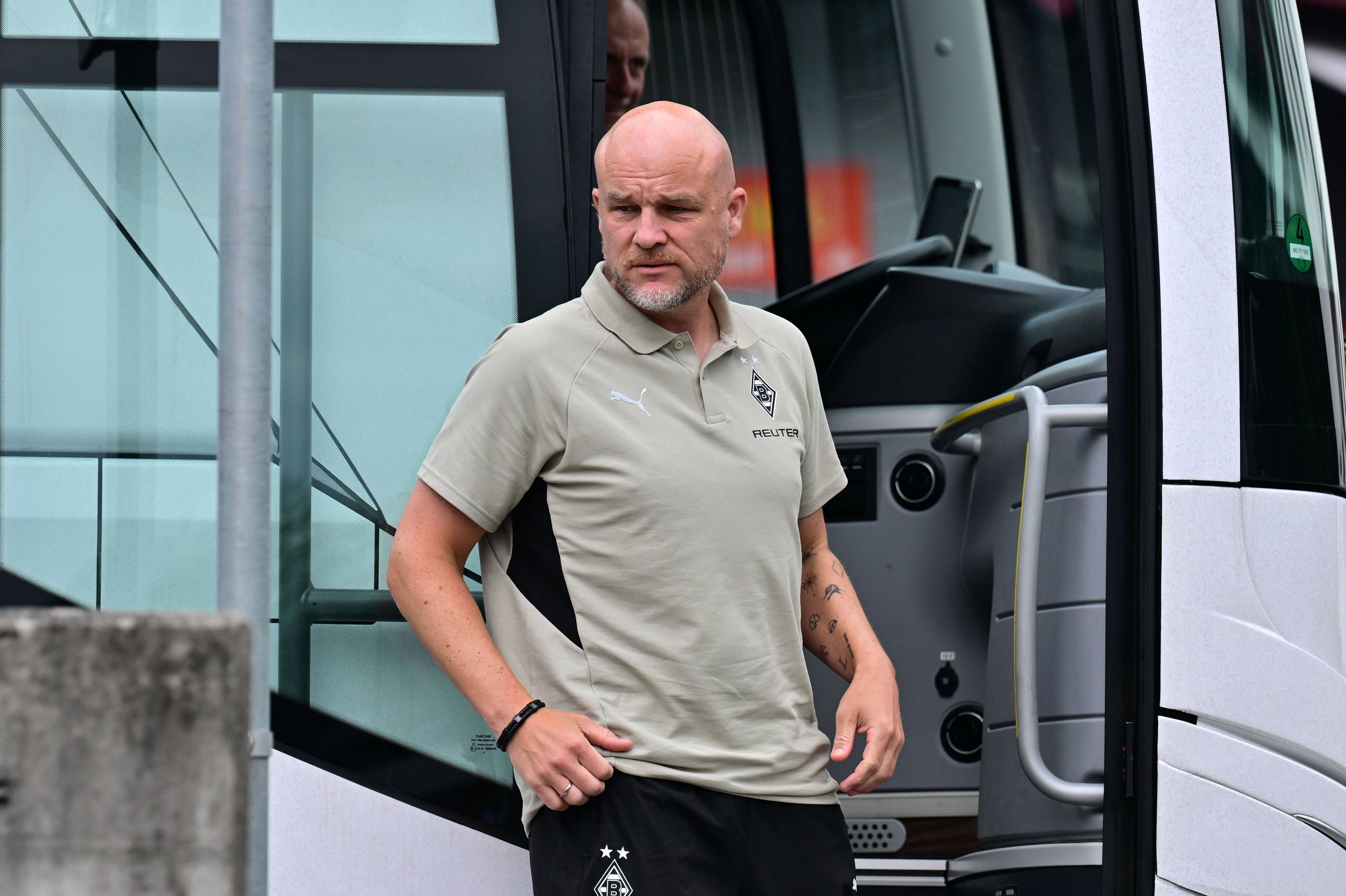 Rouven Schröder steht im Polohemd am Mannschaftsbus.