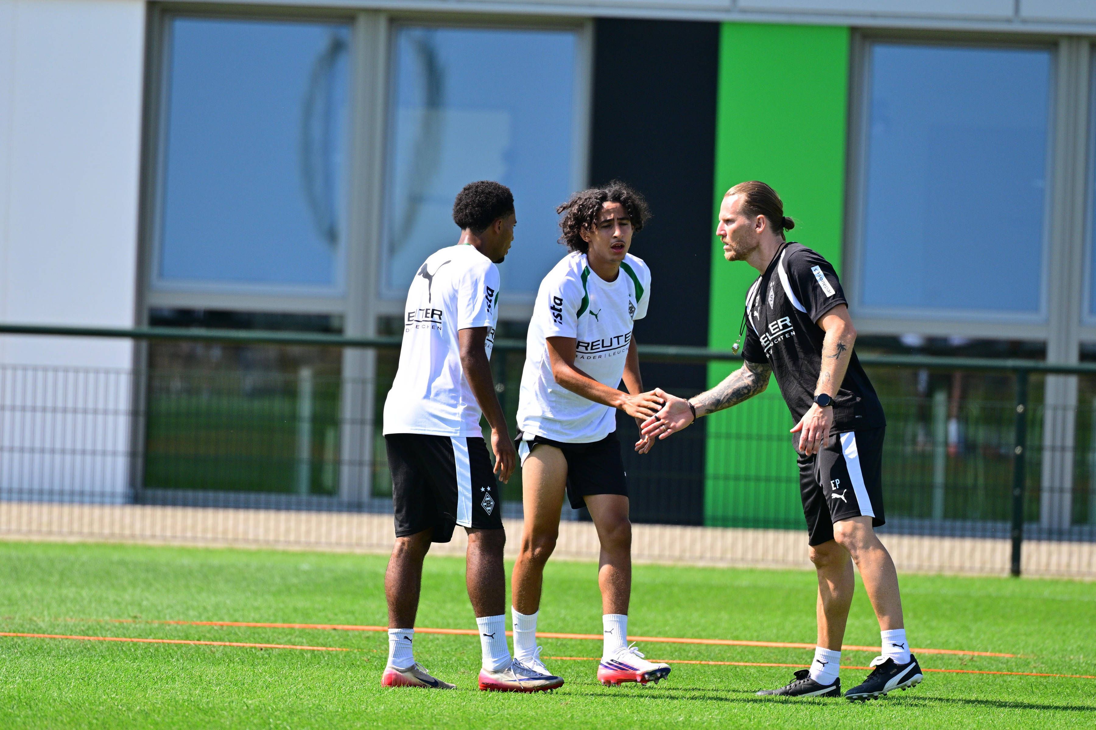 Eugen Polanski klatscht im Training mit Wael Mohya und Mathieu Nguefack ab.