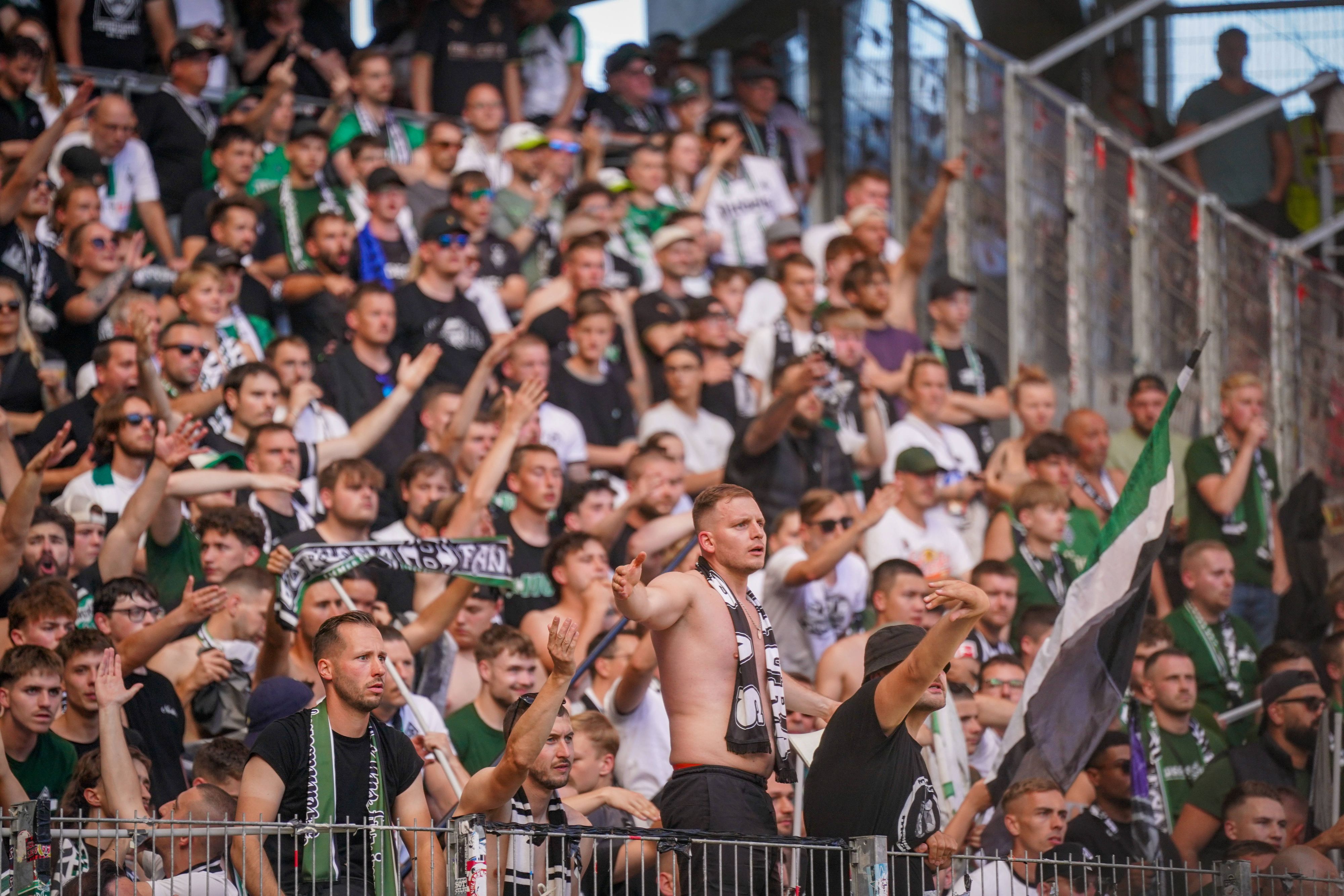 Fans von Borussia Mönchengladbach schauen frustriert aufs Spielfeld.