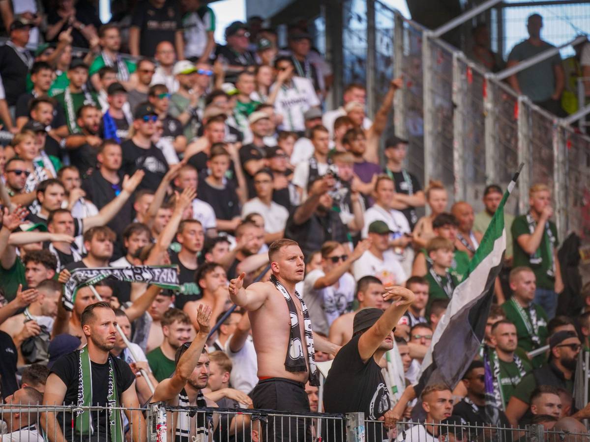 Fans von Borussia Mönchengladbach schauen frustriert aufs Spielfeld.
