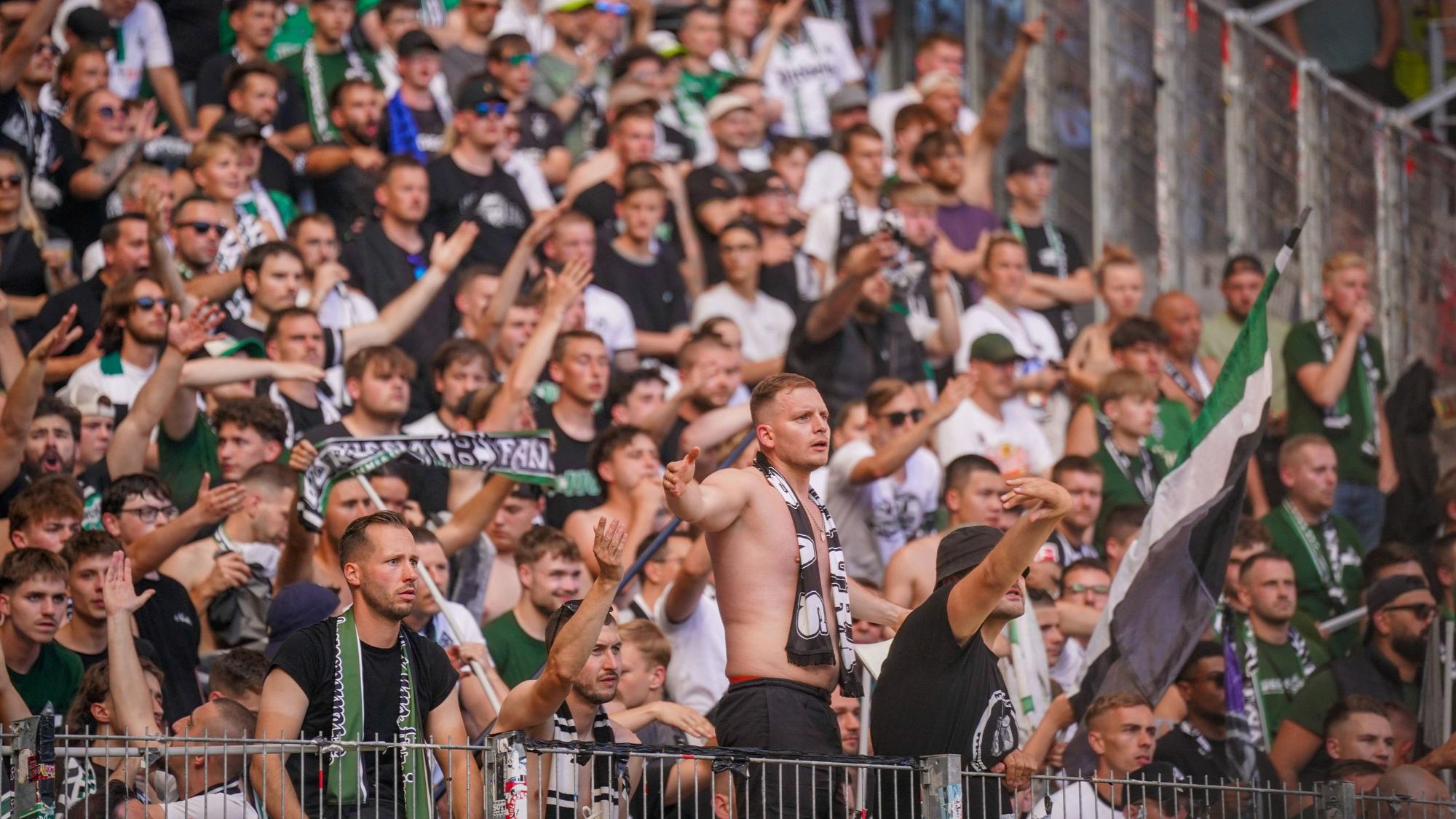 Fans von Borussia Mönchengladbach schauen frustriert aufs Spielfeld.