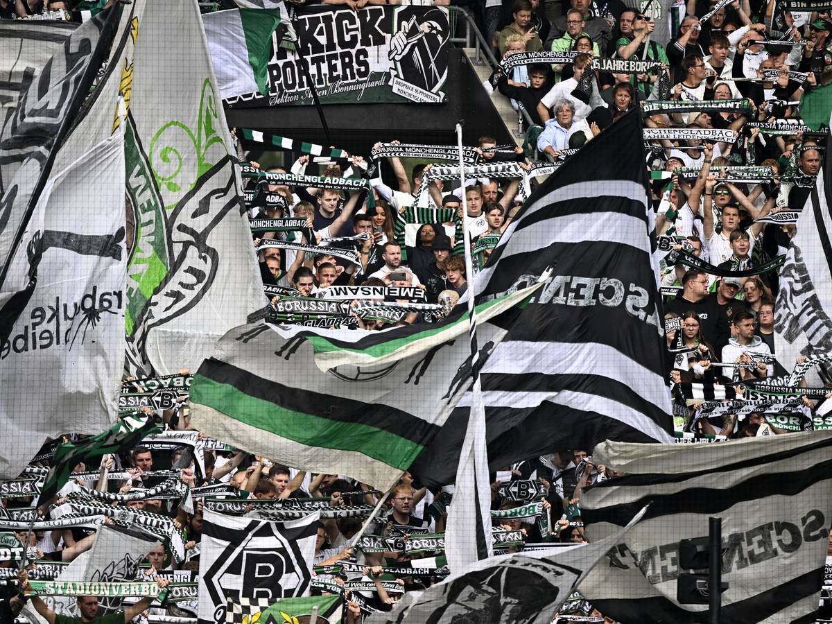 Die Fans von Borussia Mönchengladbach schwenken ihre Fahnen auf der Tribüne.