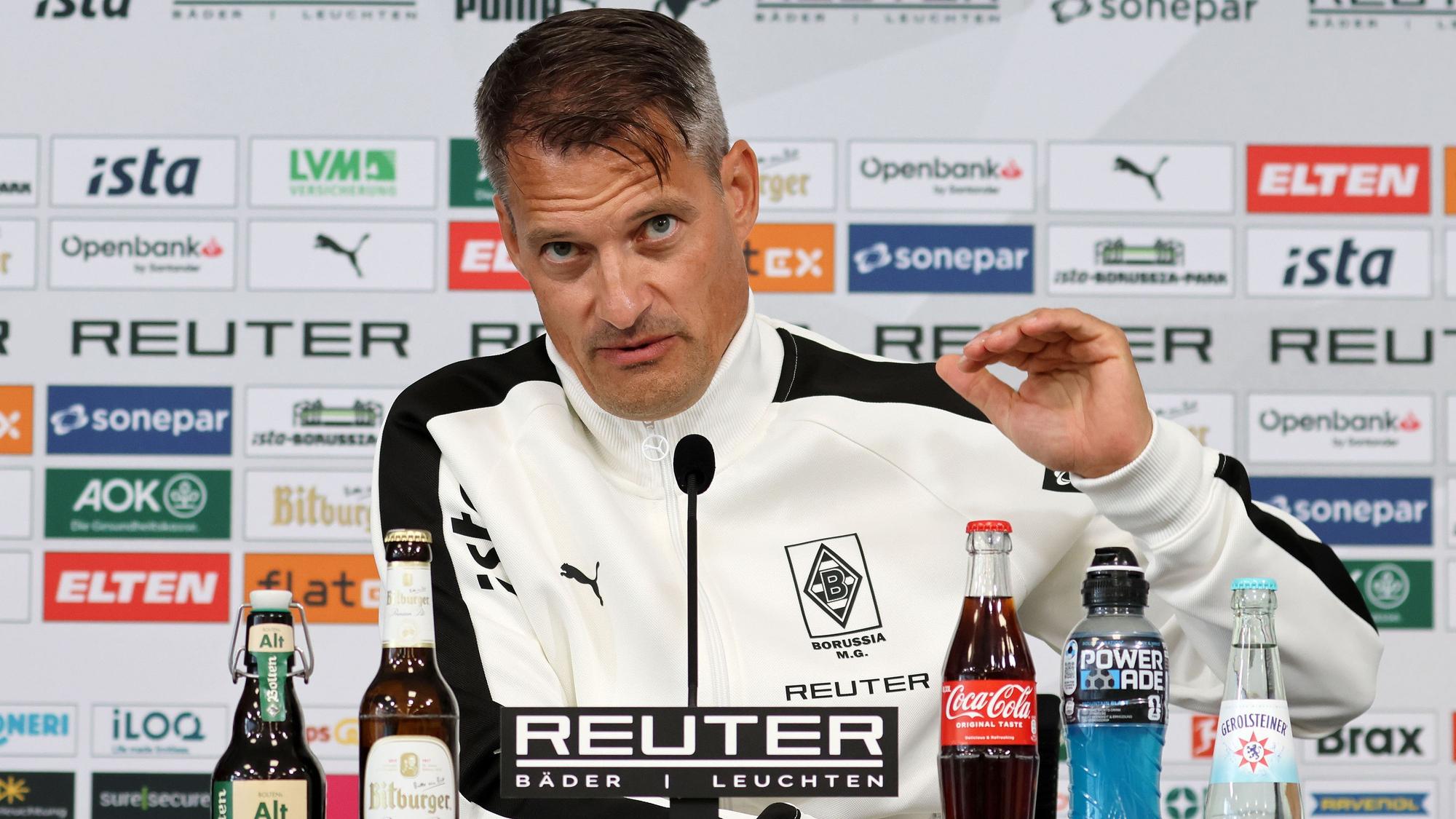 Alexander Blessin gestikuliert auf einer Gladbach-Pressekonferenz.