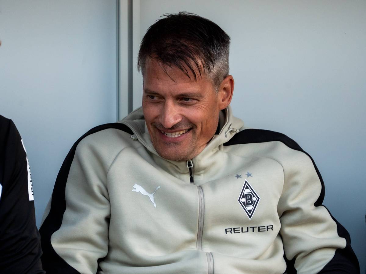 Alexander Blessin lächelt auf der Trainerbank.