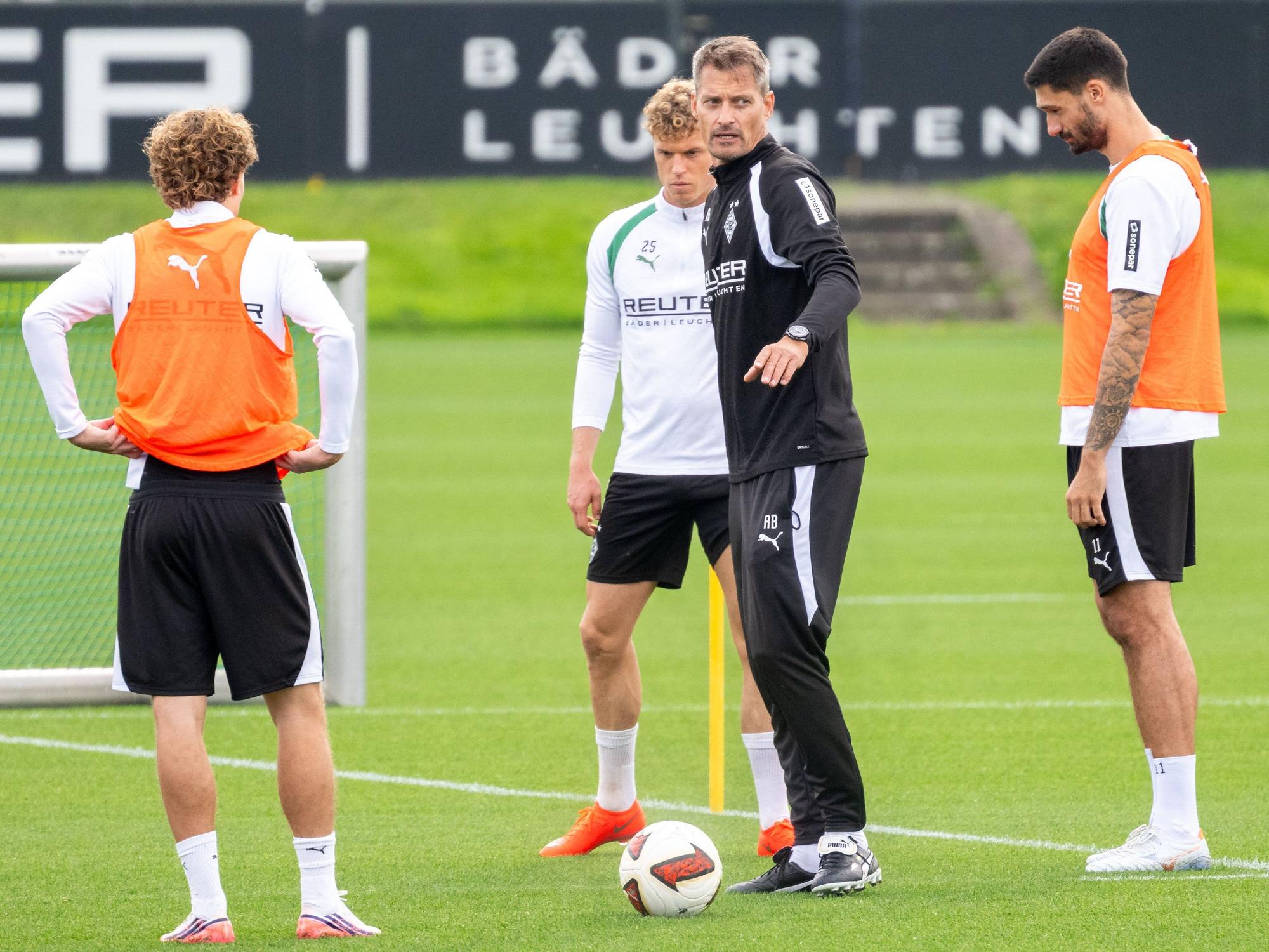 Trainer Alexander Blessin spricht im Gladbach-Training mit den Spielern.