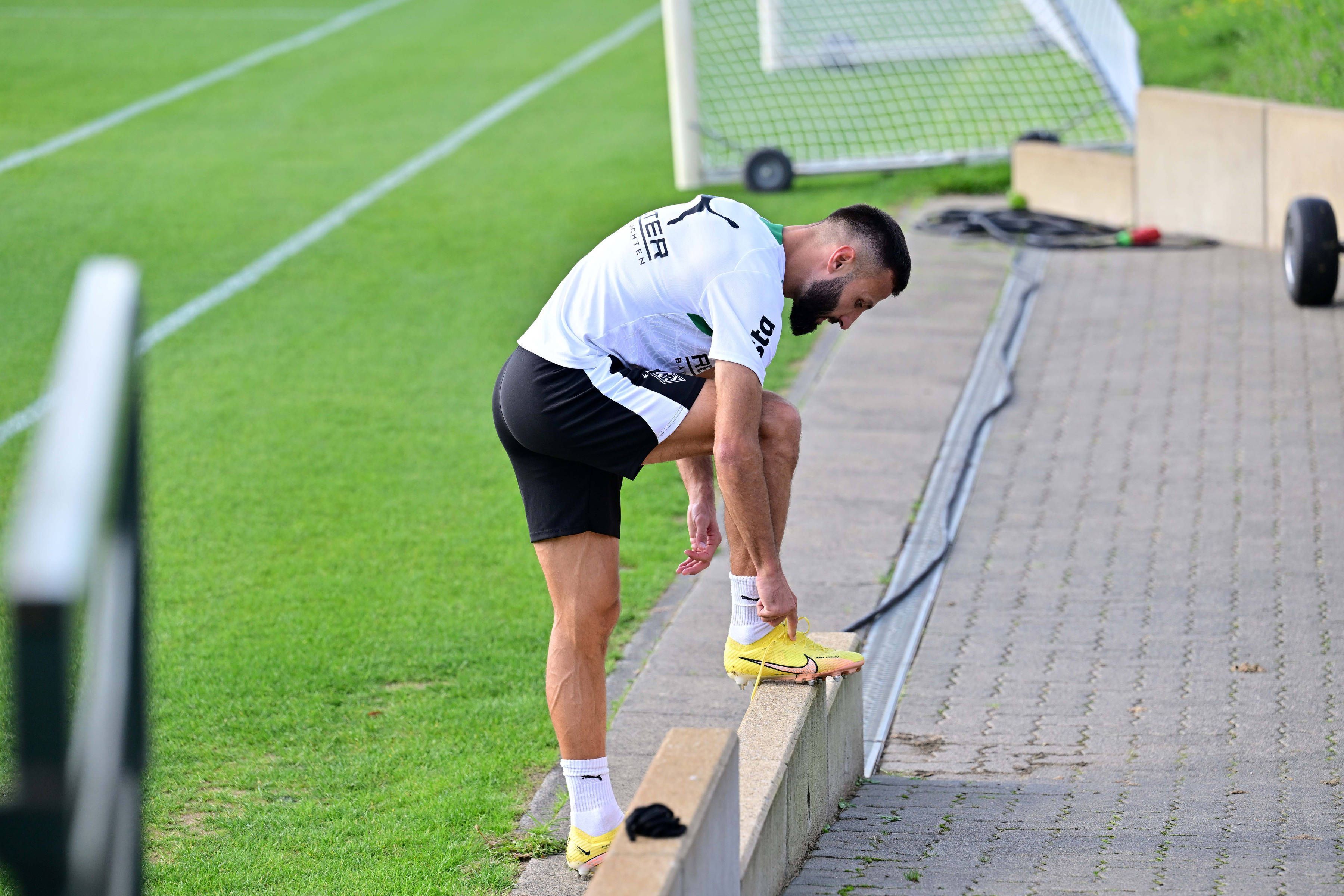 Beim Gladbach-Training bindet sich Franck Honorat die Schuhe.