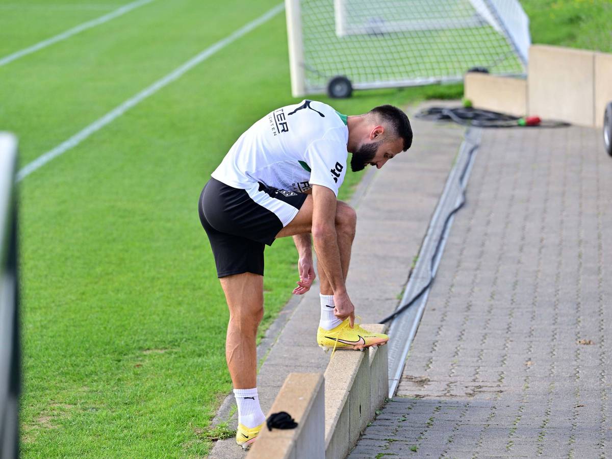 Beim Gladbach-Training bindet sich Franck Honorat die Schuhe.