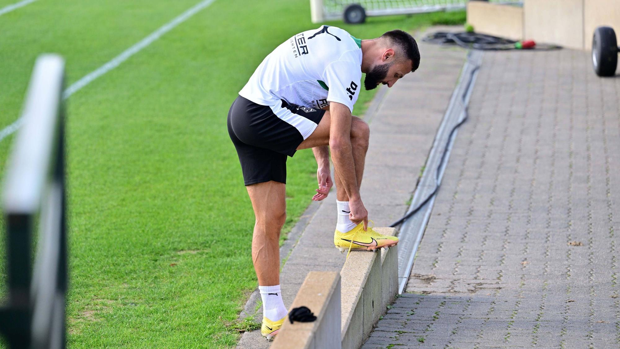 Beim Gladbach-Training bindet sich Franck Honorat die Schuhe.