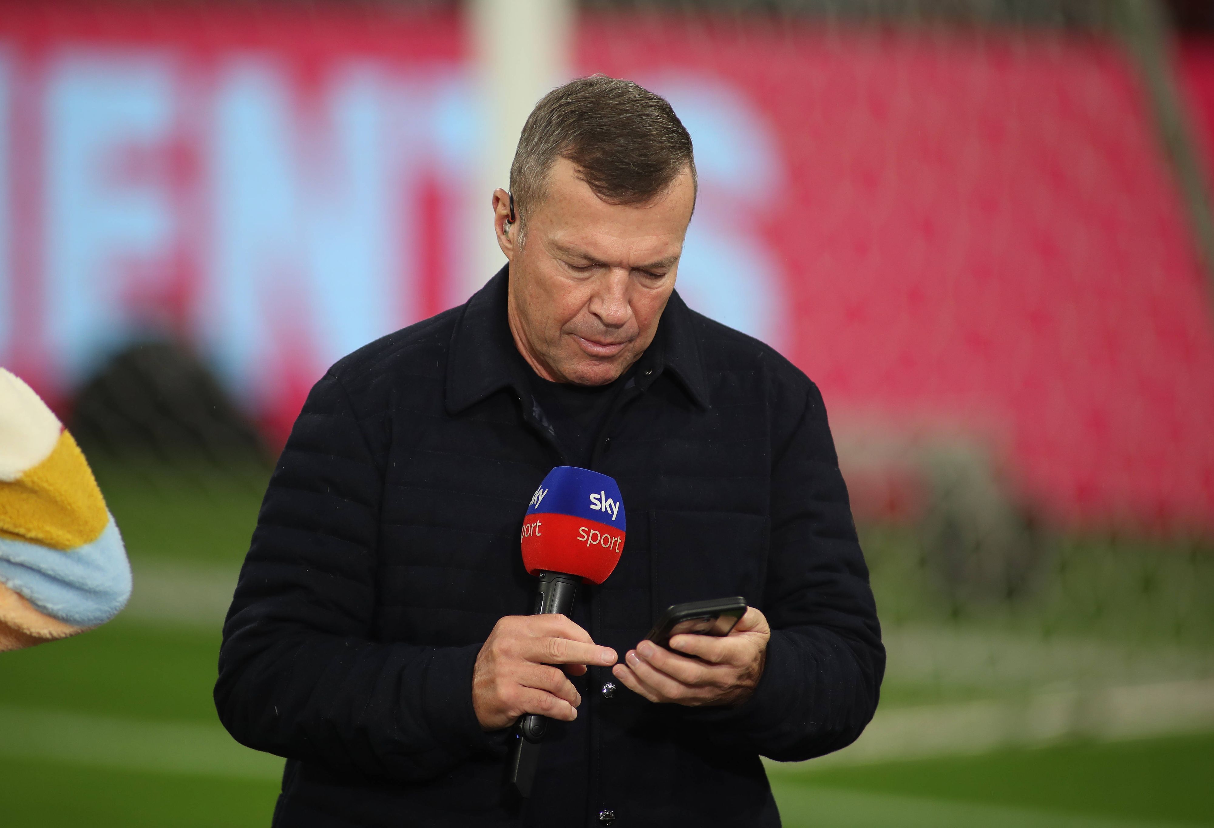 Bei einem TV-Einsatz blickt Lothar Matthäus auf sein Handy.