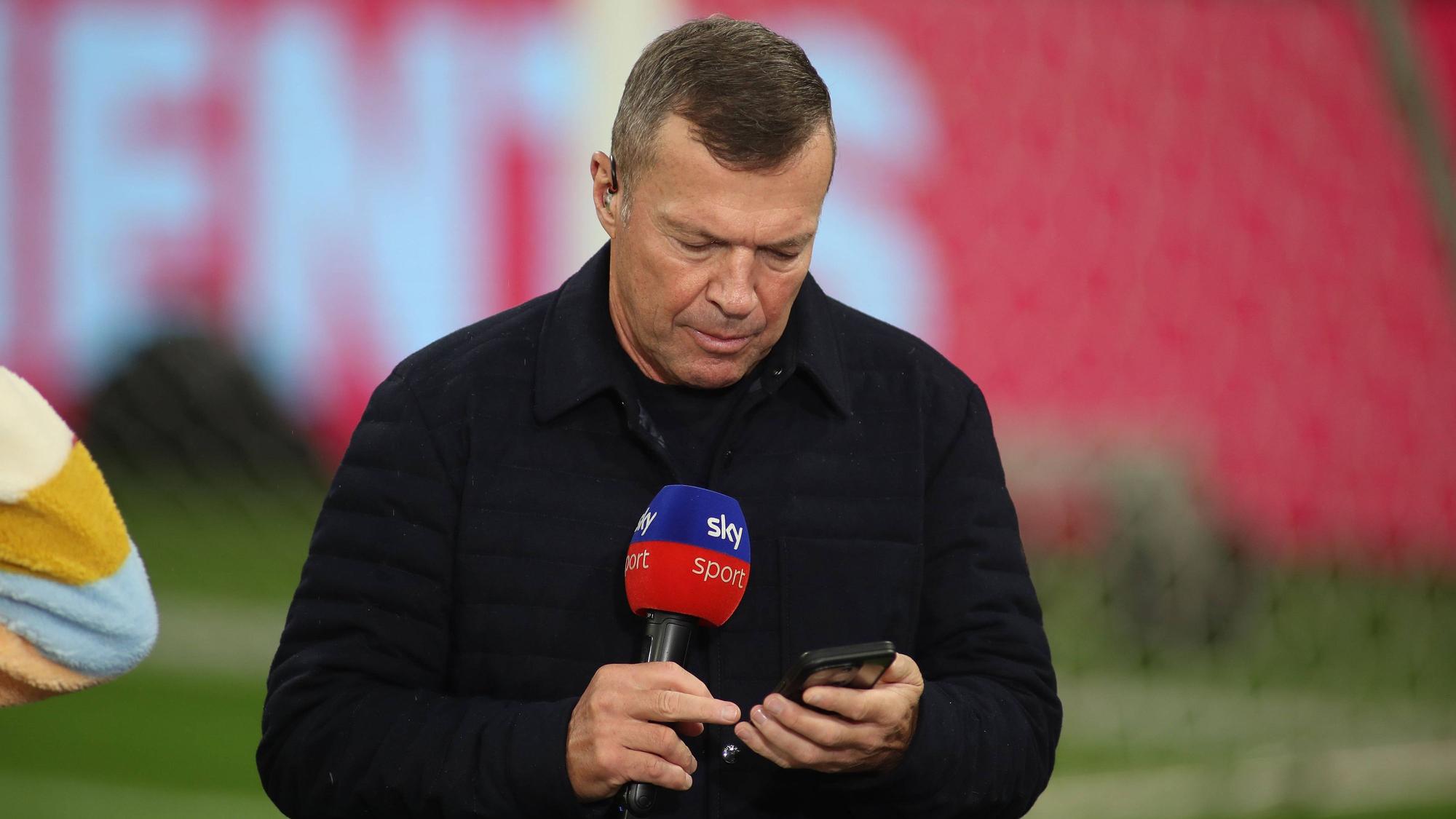 Bei einem TV-Einsatz blickt Lothar Matthäus auf sein Handy.