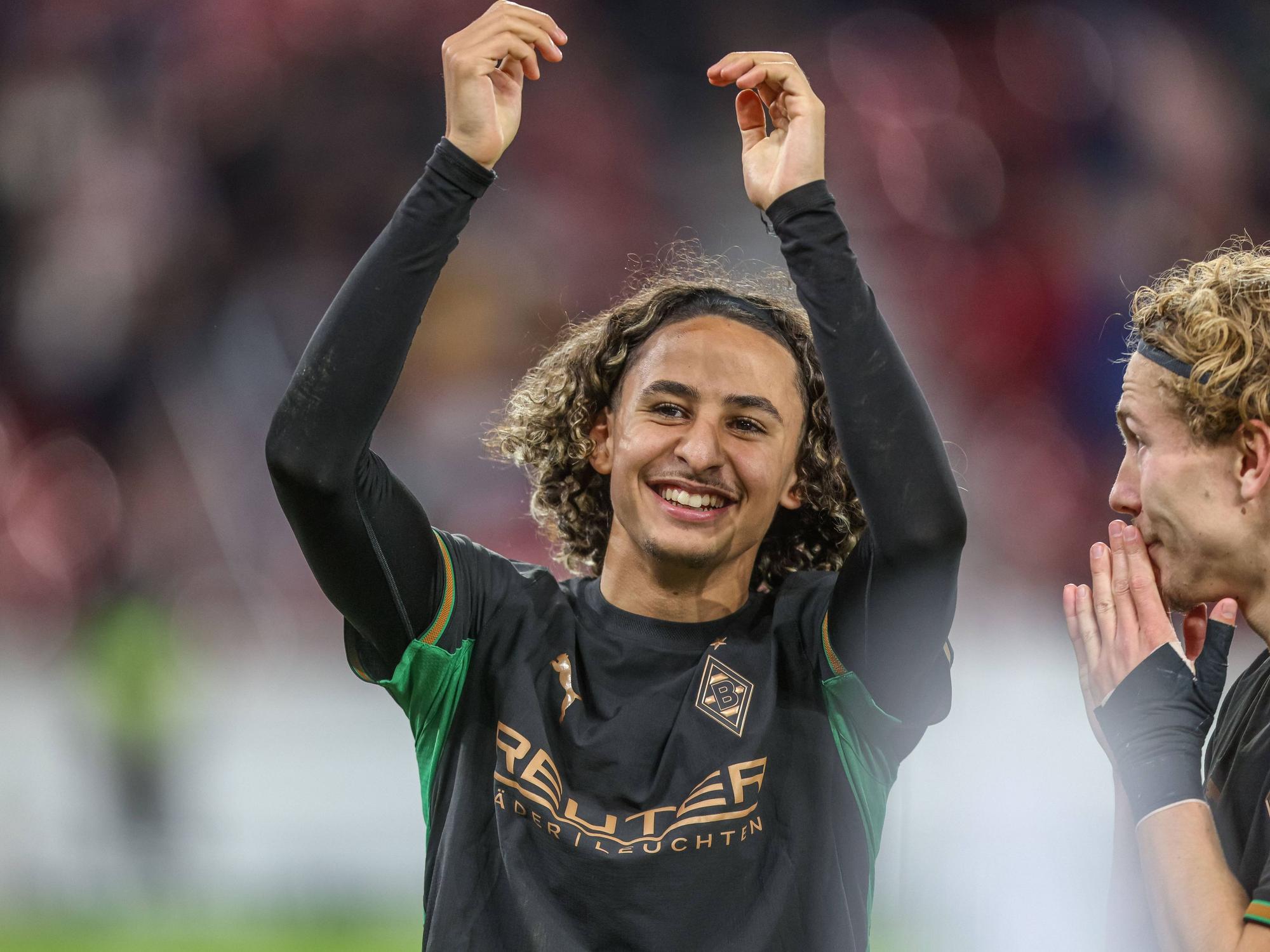 Wael Mohya hebt die Arme nach oben und freut sich.