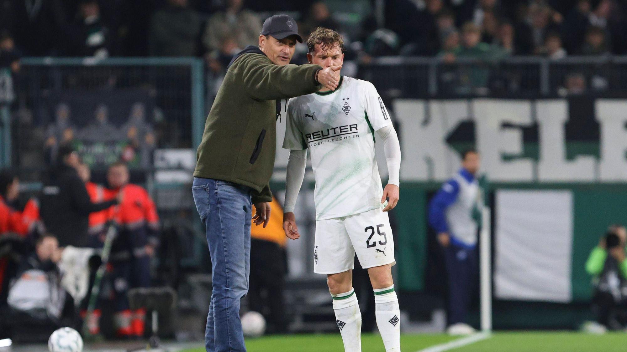 Gladbach-Trainer Alexander Blessin spricht mit Offensivspieler Robin Hack am Rande des DFB-Pokals gegen den KSC.