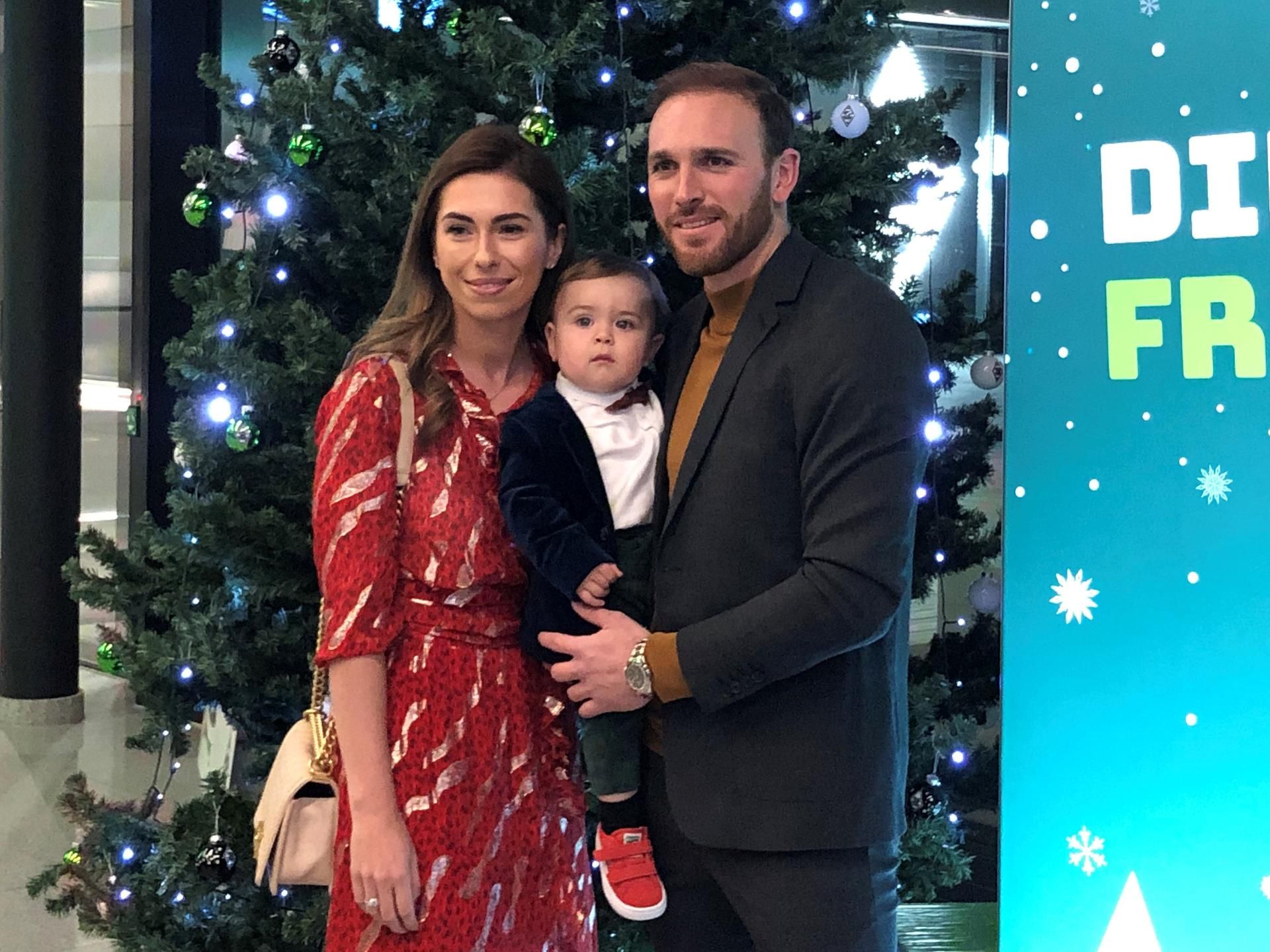 Gladbach-Torhüter Tobias Sippel (r.) mit Frau Sandra (l.) und Sohn Lenn bei der Borussia-Weihnachtsfeier 2019 im Borussia-Park. Sippel lächelt.